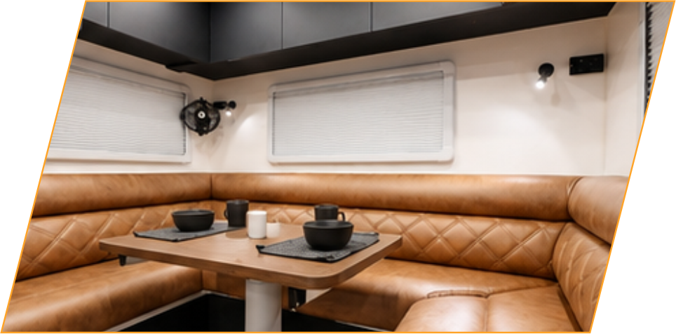 Club lounge with upholstered seating around a table inside the caravan