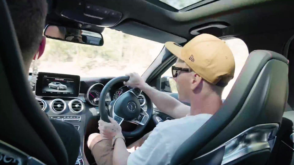 Pat behind the wheel of a Mercedes